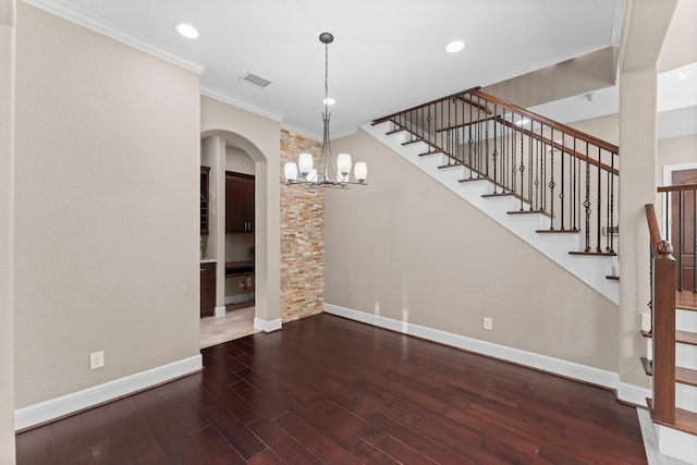 127 Benjis Pl, The Woodlands, TX 77380 - unfurnished dining area with arched walkways, ornamental molding, a chandelier, stairway, and wood finished floors