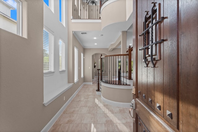 127 Benjis Pl, The Woodlands, TX 77380 - foyer entrance featuring arched walkways, ornamental molding, light tile patterned floors, and a towering ceiling