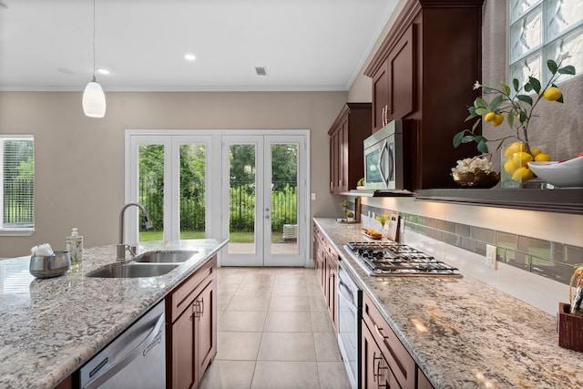 127 Benjis Pl, The Woodlands, TX 77380 - kitchen with stainless steel appliances, light stone countertops, light tile patterned flooring, decorative light fixtures, and healthy amount of natural light