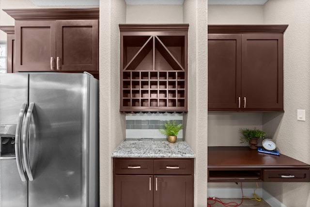 127 Benjis Pl, The Woodlands, TX 77380 - kitchen with stainless steel fridge with ice dispenser, a textured wall, light stone countertops, tasteful backsplash, and dark brown cabinets