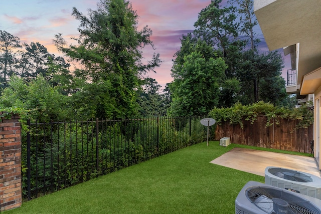 127 Benjis Pl, The Woodlands, TX 77380 - yard at dusk featuring a patio and a fenced backyard