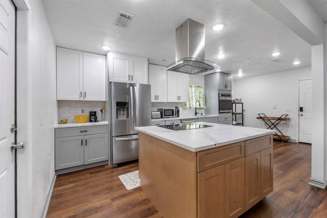 5413 Bataan Rd, Houston, TX 77033 - kitchen featuring stainless steel appliances, island range hood, backsplash, dark wood-type flooring, and recessed lighting