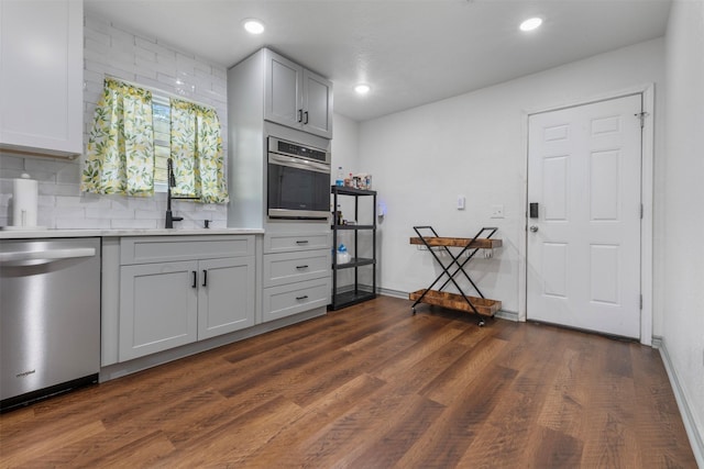 5413 Bataan Rd, Houston, TX 77033 - kitchen with appliances with stainless steel finishes, tasteful backsplash, dark wood-type flooring, light countertops, and recessed lighting