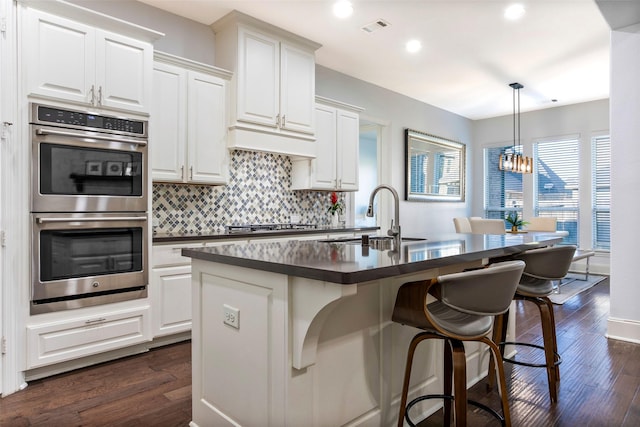 29110 Davenport Dr, Katy, TX 77494 - kitchen with stainless steel double oven, dark countertops, a chandelier, backsplash, and dark wood-style flooring