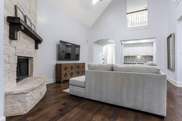 29110 Davenport Dr, Katy, TX 77494 - living room featuring high vaulted ceiling, a stone fireplace, arched walkways, and dark wood-style floors