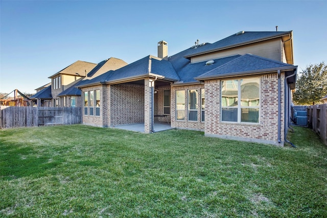 29110 Davenport Dr, Katy, TX 77494 - back of house featuring brick siding, a fenced backyard, a patio area, and a chimney