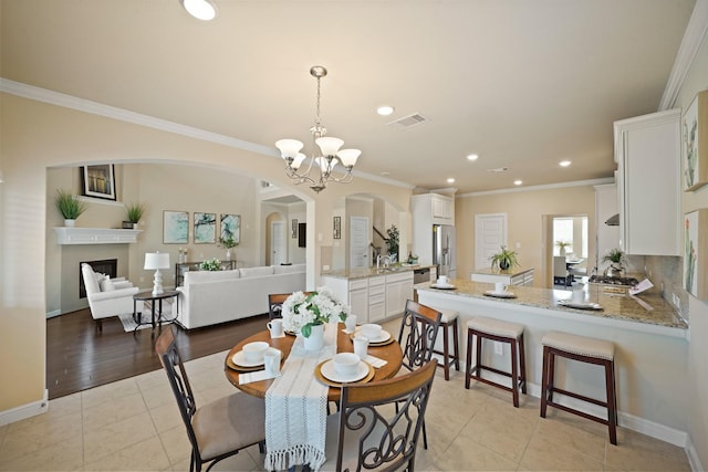 5706 Jenolan Ridge Ln, Sugar Land, TX 77479 - dining area with arched walkways, a chandelier, crown molding, recessed lighting, and light tile patterned flooring