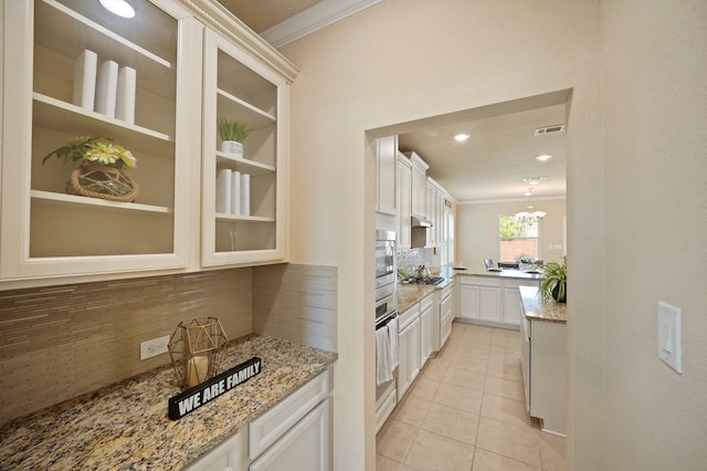 5706 Jenolan Ridge Ln, Sugar Land, TX 77479 - kitchen featuring decorative backsplash, ornamental molding, light tile patterned floors, appliances with stainless steel finishes, and light stone countertops