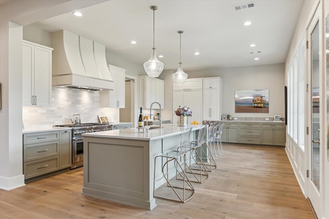 1710 Ebony Ln, Houston, TX 77018 - kitchen with high end stainless steel range oven, premium range hood, light countertops, gray cabinets, and recessed lighting