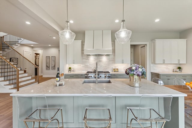 1710 Ebony Ln, Houston, TX 77018 - kitchen with custom exhaust hood, decorative backsplash, recessed lighting, light stone countertops, and light wood-style flooring