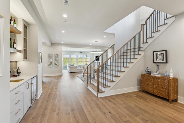 1710 Ebony Ln, Houston, TX 77018 - staircase with wood finished floors, recessed lighting, ceiling fan, and beverage cooler