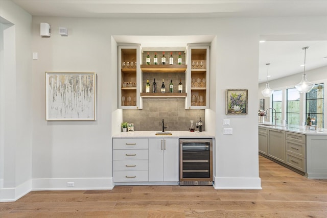 1710 Ebony Ln, Houston, TX 77018 - indoor wet bar with beverage cooler, light wood-type flooring, decorative backsplash, and hanging light fixtures