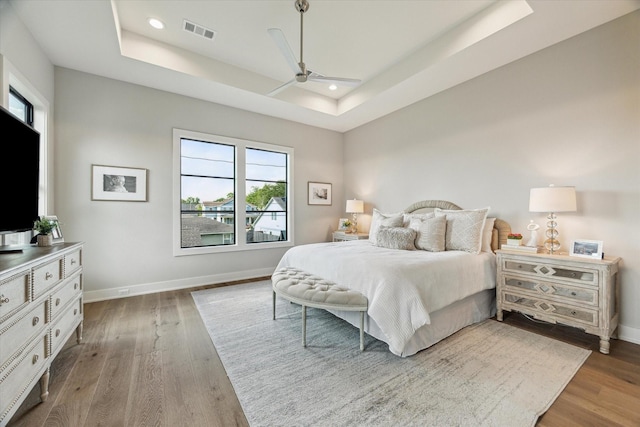 1710 Ebony Ln, Houston, TX 77018 - bedroom featuring a tray ceiling, multiple windows, wood finished floors, recessed lighting, and ceiling fan