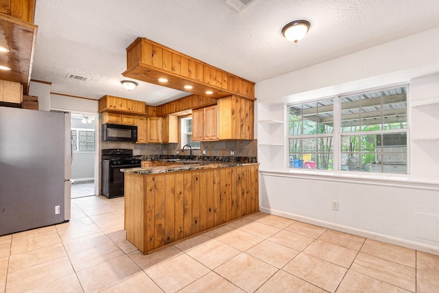 306 Hickory Ridge Dr, Shenandoah, TX 77381 - kitchen with black appliances, backsplash, a peninsula, a textured ceiling, and light tile patterned flooring