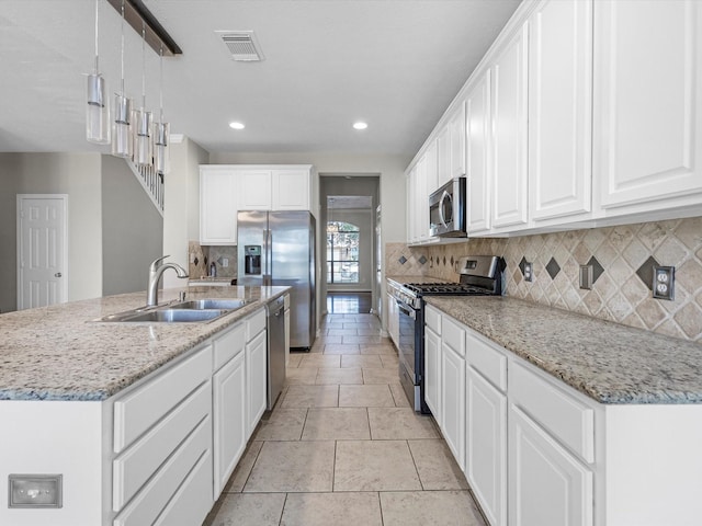 4315 Countrycrossing Dr, Spring, TX 77388 - kitchen with stainless steel appliances, white cabinetry, backsplash, recessed lighting, and an island with sink