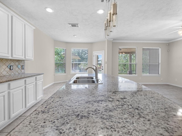 4315 Countrycrossing Dr, Spring, TX 77388 - kitchen with a textured ceiling, white cabinets, decorative backsplash, light stone countertops, and ceiling fan