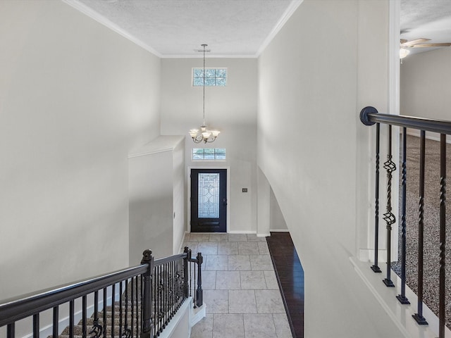 4315 Countrycrossing Dr, Spring, TX 77388 - entryway featuring a chandelier, stone tile floors, a textured ceiling, ornamental molding, and a ceiling fan
