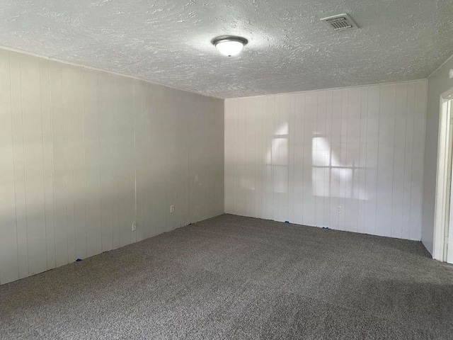 6523 Hanley Ln, Houston, TX 77016 - spare room featuring carpet flooring, a textured ceiling, and wooden walls