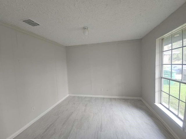 6523 Hanley Ln, Houston, TX 77016 - spare room with a textured ceiling, light wood-type flooring, and healthy amount of natural light