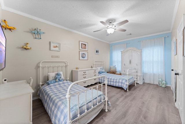1518 Honea Egypt Rd, Magnolia, TX 77354 - bedroom featuring ornamental molding, light wood-type flooring, a ceiling fan, and a textured ceiling