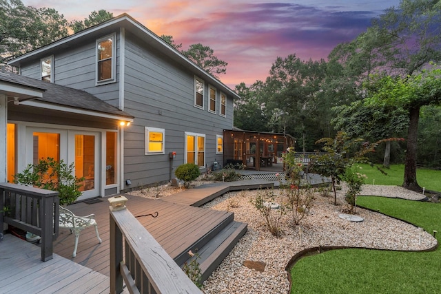 1518 Honea Egypt Rd, Magnolia, TX 77354 - back of house at dusk with a deck, roof with shingles, and a lawn