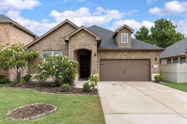 10005 Red Beadtree Pl, Conroe, TX 77385 - french country inspired facade featuring brick siding, an attached garage, driveway, and roof with shingles