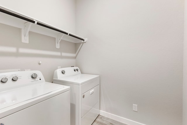 10005 Red Beadtree Pl, Conroe, TX 77385 - laundry room with washer and clothes dryer and light wood-style flooring