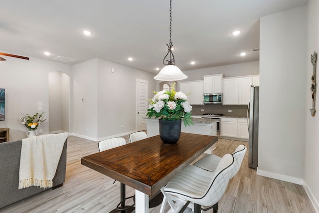 10005 Red Beadtree Pl, Conroe, TX 77385 - dining room featuring arched walkways, light wood-style flooring, recessed lighting, and a ceiling fan