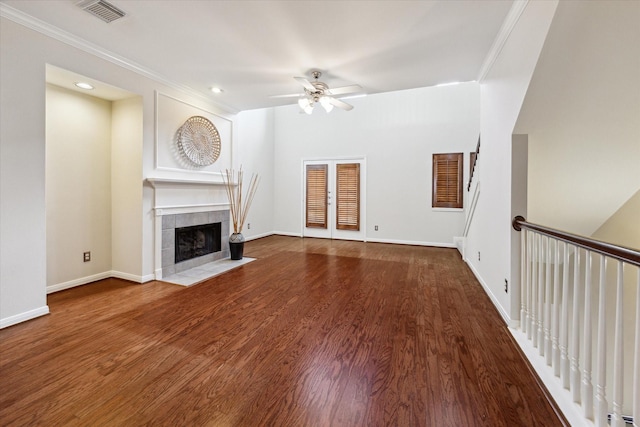 1606 Sutton St, Houston, TX 77006 - unfurnished living room featuring a ceiling fan, a tiled fireplace, ornamental molding, wood finished floors, and recessed lighting