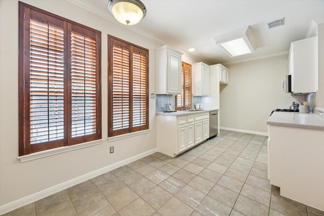1606 Sutton St, Houston, TX 77006 - kitchen with stainless steel dishwasher, light countertops, light tile patterned floors, white cabinets, and ornamental molding