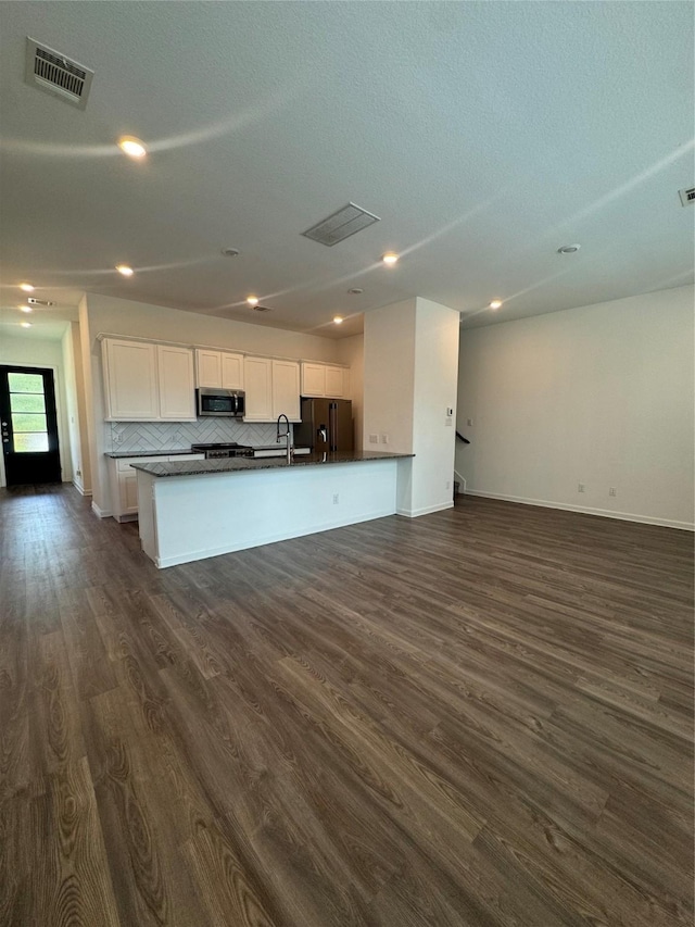 4727 Glen Isle Dr, Houston, TX 77009 - kitchen with refrigerator with ice dispenser, open floor plan, stainless steel microwave, white cabinetry, and recessed lighting