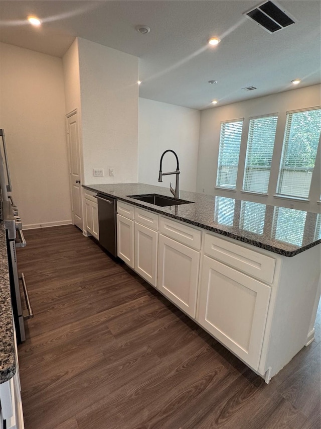 4727 Glen Isle Dr, Houston, TX 77009 - kitchen featuring dishwasher, white cabinetry, dark wood-type flooring, dark stone counters, and recessed lighting