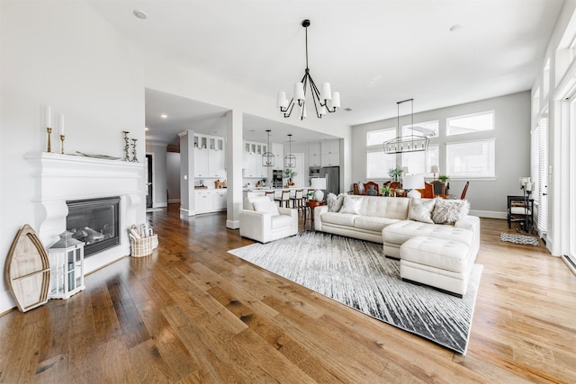 3239 Caney Dr, Katy, TX 77493 - living area with a chandelier, wood finished floors, and a glass covered fireplace