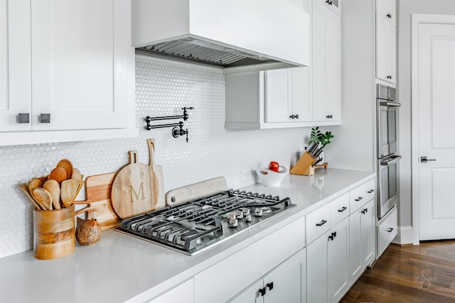 3239 Caney Dr, Katy, TX 77493 - kitchen featuring custom range hood, stainless steel appliances, light countertops, white cabinetry, and backsplash