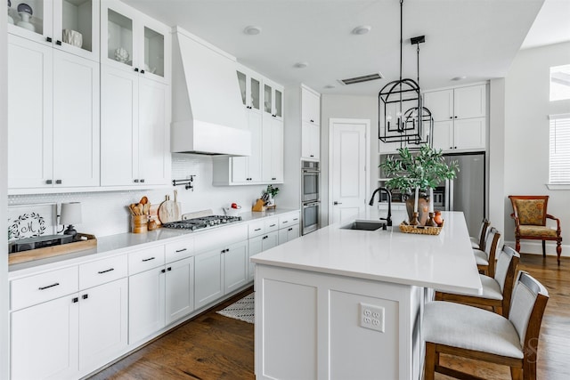 3239 Caney Dr, Katy, TX 77493 - kitchen with custom range hood, stainless steel appliances, dark wood-style flooring, and tasteful backsplash