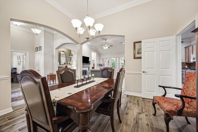 1607 N Primavera Dr, Pearland, TX 77581 - dining room featuring arched walkways, a chandelier, dark wood-style flooring, crown molding, and a ceiling fan