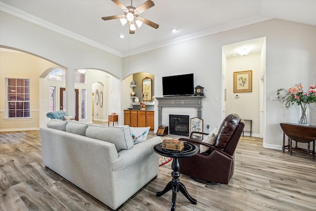 1607 N Primavera Dr, Pearland, TX 77581 - living area with arched walkways, a ceiling fan, light wood-type flooring, a glass covered fireplace, and recessed lighting