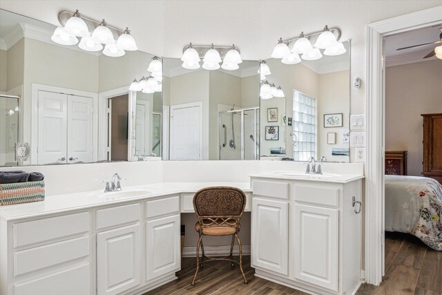 1607 N Primavera Dr, Pearland, TX 77581 - bathroom featuring ornamental molding, connected bathroom, a shower stall, double vanity, and wood finished floors