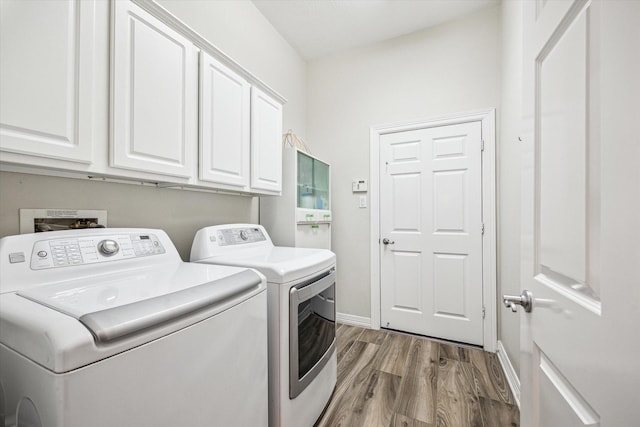 1607 N Primavera Dr, Pearland, TX 77581 - laundry room featuring cabinet space, washer and clothes dryer, and wood finished floors