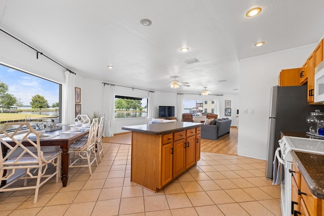 20559 Red Bud Ct, Thornton, TX 76687 - kitchen with white appliances, recessed lighting, light tile patterned floors, open floor plan, and a kitchen island