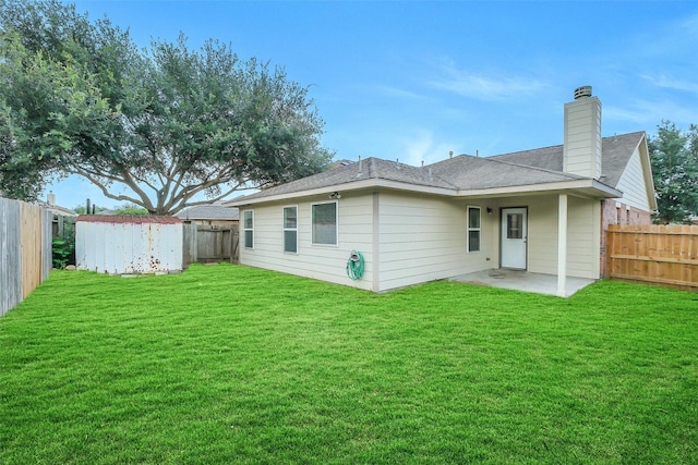 10143 Rose Willow Ln, Brookshire, TX 77423 - rear view of property featuring a patio, a storage unit, a fenced backyard, a chimney, and a shingled roof