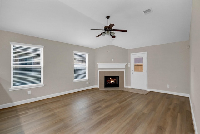 10143 Rose Willow Ln, Brookshire, TX 77423 - unfurnished living room with lofted ceiling, ceiling fan, wood finished floors, healthy amount of natural light, and a tile fireplace