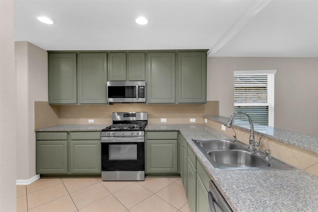 10143 Rose Willow Ln, Brookshire, TX 77423 - kitchen featuring appliances with stainless steel finishes, green cabinetry, light countertops, backsplash, and light tile patterned flooring