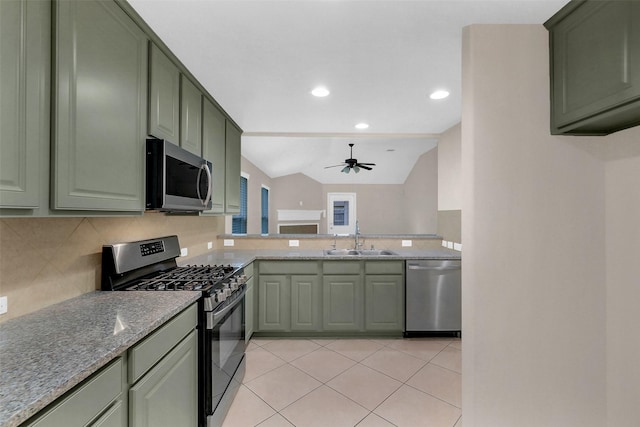 10143 Rose Willow Ln, Brookshire, TX 77423 - kitchen with stainless steel appliances, green cabinets, backsplash, a ceiling fan, and light stone counters
