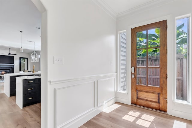 5406 Darling St Unit A, Houston, TX 77007 - entryway with light wood-style floors, ornamental molding, arched walkways, ceiling fan, and a glass covered fireplace