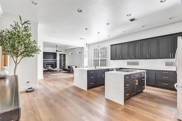5406 Darling St Unit A, Houston, TX 77007 - kitchen featuring light countertops, open floor plan, a center island, a ceiling fan, and a glass covered fireplace