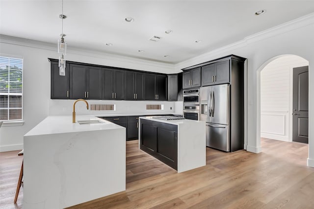 5406 Darling St Unit A, Houston, TX 77007 - kitchen featuring appliances with stainless steel finishes, crown molding, arched walkways, light countertops, and dark cabinetry