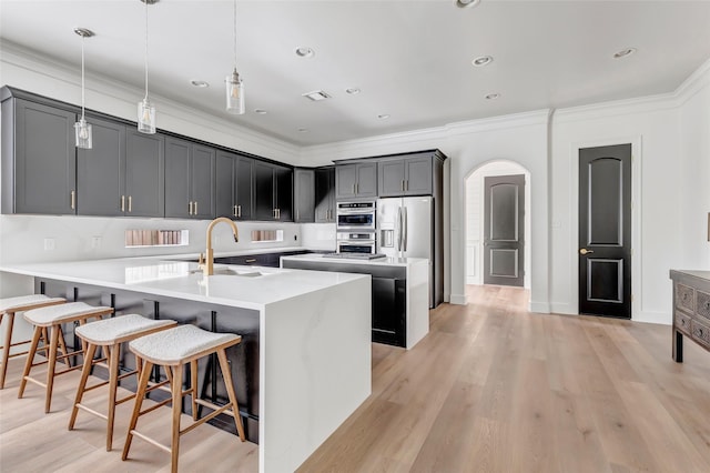5406 Darling St Unit A, Houston, TX 77007 - kitchen featuring a peninsula, arched walkways, a kitchen breakfast bar, stainless steel appliances, and ornamental molding