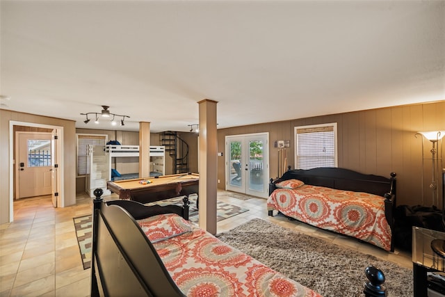 374 W Lake Shore Dr, Livingston, TX 77351 - bedroom featuring access to exterior, multiple windows, light tile patterned floors, and wooden walls