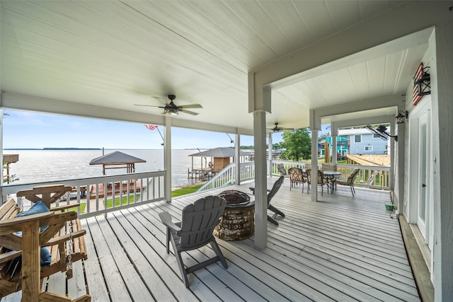 374 W Lake Shore Dr, Livingston, TX 77351 - wooden terrace featuring a fire pit, ceiling fan, a water view, and outdoor dining area